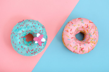 Sweet donuts, blue on pink, pink on blue. Concept conflict of contradictions, individuality in the generalization, the game of color, desserts. Copy space, blue and pink backgrounds