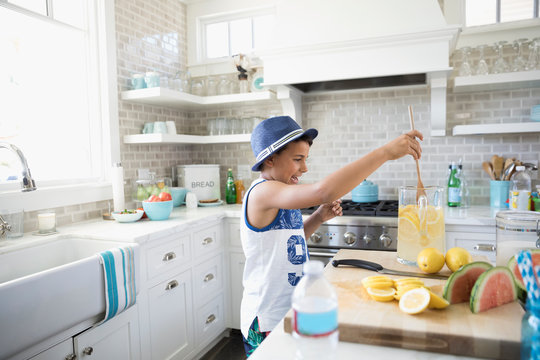 Boy Making Lemonade In Beach House Kitchen