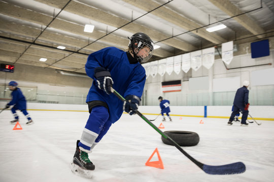 Boy Ice Hockey Player Practicing Drills On Ice Hockey Rink