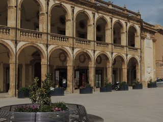 Mazara del Vallo &ndash; Episcopal Palace facade with yellow stone wall, an open gallery, colonnaded porticoes and terraces