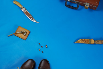 flat lay layout of men's leather accessories. Leather high boots with a knife in the bootleg - a...
