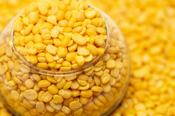 A close up of yellow peeled mung bean stay in transparent mini jar glass