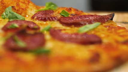 ppetizing hot pepperoni pizza lies on a tray. Close-up. Slow motion