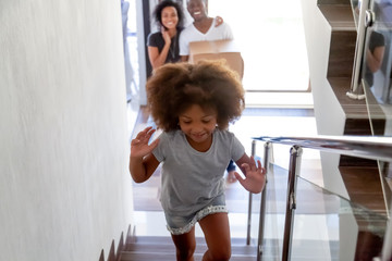 Excited little girl run upstairs exploring new home