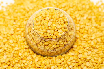A center close up of yellow peeled mung bean stay in transparent mini jar glass