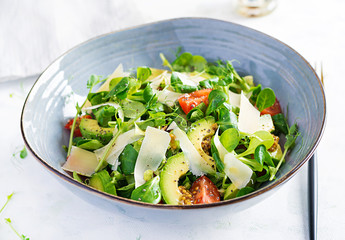 Healthy salad of fresh vegetables - tomatoes, avocado, corn salad, pea sprouts and chia seeds in bowl. Paleo diet menu.