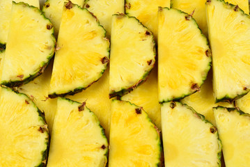 Pineapple juicy yellow slices background. Top view.
