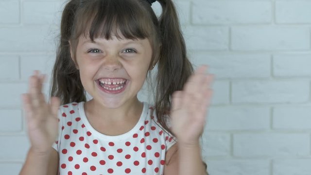 Portrait of a happy kid. Child clap hands.