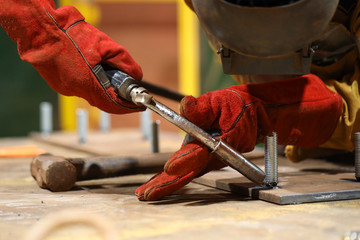 Isolated arc welder wearing safety welding glove, eyes protection performing welding at the...