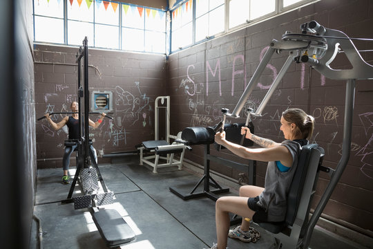 Fit woman weightlifting in gritty gym