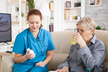 Obraz premium Medical nurse helping senior woman in nursing home