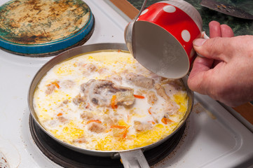 the process of cooking chicken in a creamy sauce.