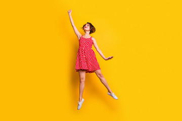Full size photo of cute cheerful pretty girl jump hold hand want catch flying parasol wear good look vintage style skirt shoes isolated over yellow color background