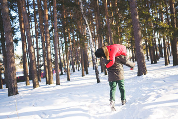 Happy man running with a woman on his shoulder in the forest park