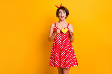 Astonished funny girl celebrate 14-february date hold yellow small paper card heart she receive passionate boyfriend wear vintage style red bright skirt isolated shine color background
