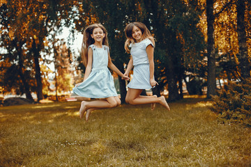 Beautiful girls on a blue dresses. Friends have fun in a summer park