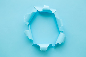 Breakthrough paper hole blue abstract. Space for copy.
