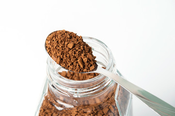 Instant coffee granules in a spoon, macro, on white background