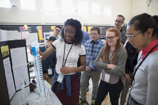 Middle school students watching scientific experiment at science fair
