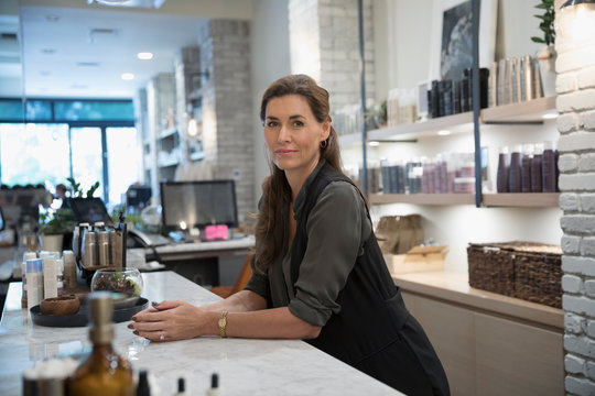 Portrait Confident Female Salon Shop Owner At Counter