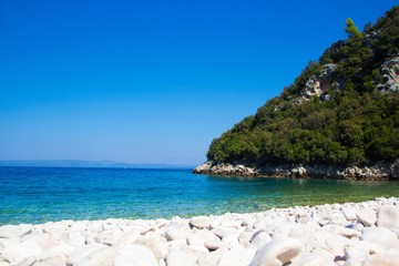 Fototapeta na wymiar A picturesque piece of nature. Sea, pebbles, mountains.Croatian coast, a piece of wild beach.
