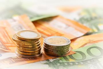Stack of euro coins on euro banknotes, for backgrounds and with copy space.