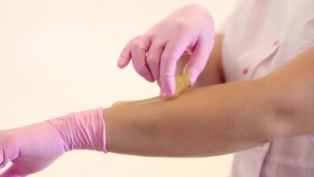 Hands in rubber gloves close-up. doctor puts wax, honey. medic is preparing for depilation. Concept of medicine, health care, beauty industry, hair removal, natural material. Copy space