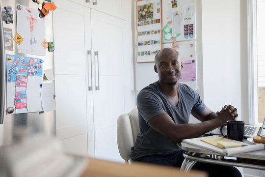 Portrait Confident Mature African American Man Working At Laptop At Kitchen Table