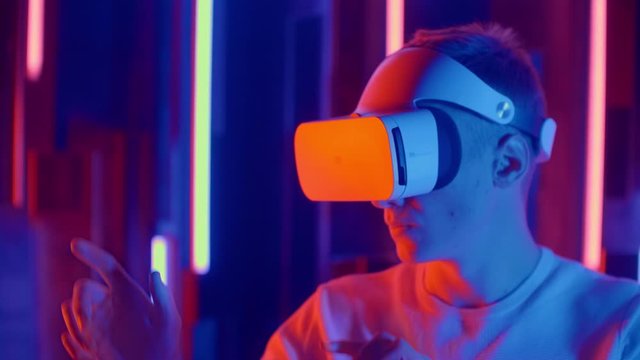 Young man Wearing Virtual Reality Headset Draws Abstract Lines. Creative Young Girl Does Concept Art with Augmented Reality.