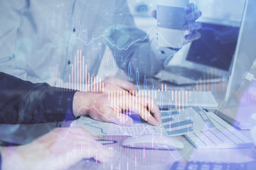 Fototapeta premium Multi exposure of chart with man typing on computer in office on background. Concept of hard work.