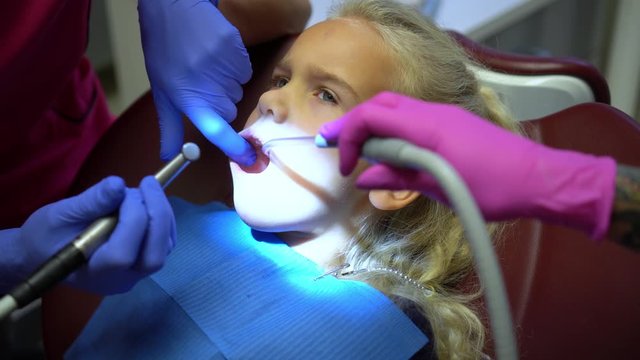 Doctor hands work with drill. Child open mouth during drilling caries in teeth
