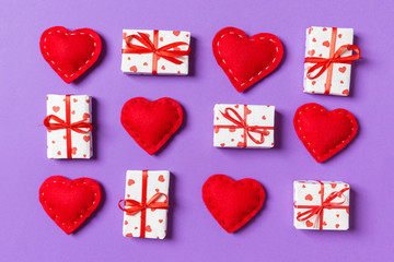 Top view of white gift boxes and red textile hearts on colorful background. Valentine's Day concept