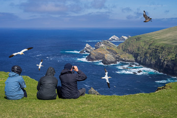 Birdwatchers watching seabirds at Hermaness, Shetland, Scotland, UK