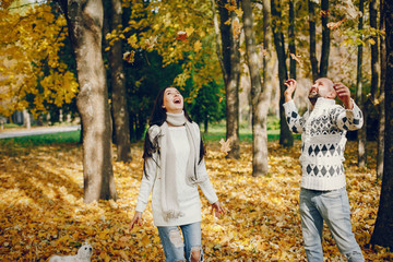 Fototapeta premium Couple in a park. Brunette in a white sweater. Man with a beard