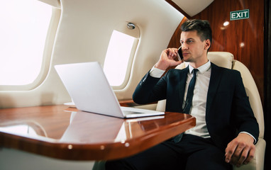 Traveling abroad. Close-up photo of a serious man in formal clothes, who is looking through the...