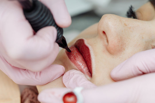 Woman Having Permanent Makeup On Lips In Beauty Salon