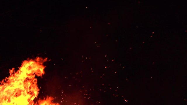Forest fires, Burning fire. Big Fire flames with flying sparks background. Firestorm texture, shot of flying sparks in the air on black. Burning bonfire over dark night backdrop. Slow motion 4K