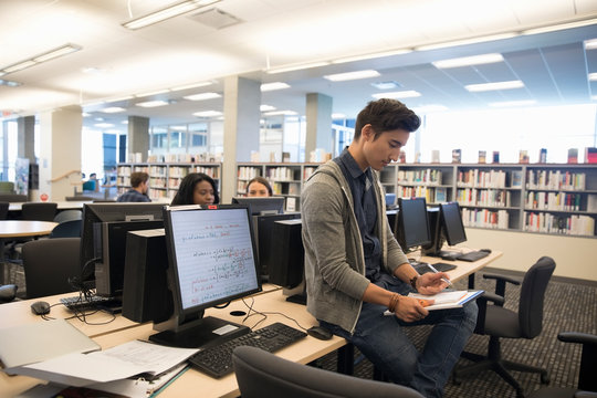 Male College Student Studying In Library