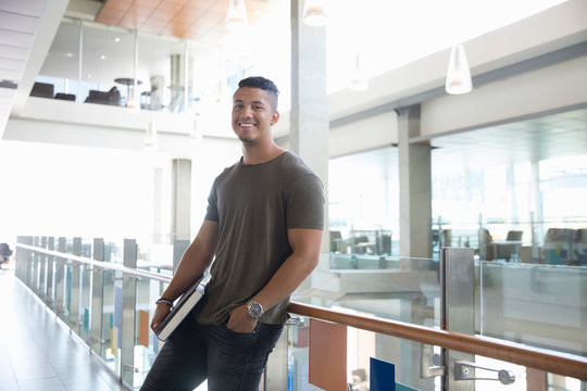 Portrait Smiling Male College Student Leaning Against Balcony Railing