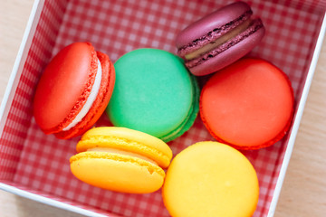 French traditional delicious dessert. Sweet macaroons in a gift box on wooden table