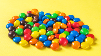 Fototapeta na wymiar Multicolored glazed button candies closeup