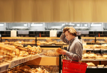 Teenager choosing bread from a supermarket	