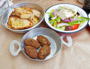 Greek salad, meat balls and toasted bread served