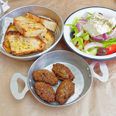 Greek salad, meat balls and toasted bread served