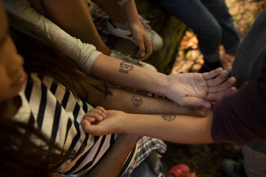 Boy And Girl Friends With Matching Temporary Tattoos On Forearms