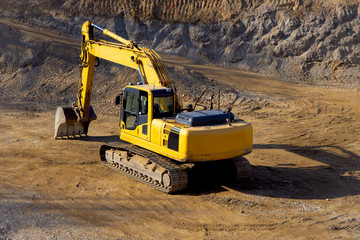 Yellow excavator/bulldozer on construction site.
