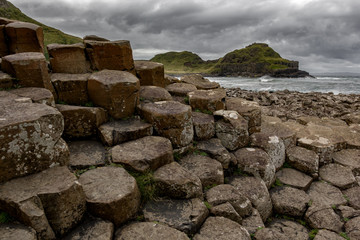 Basalt columns of Giants Causeway in Ireland under dramatic sky.