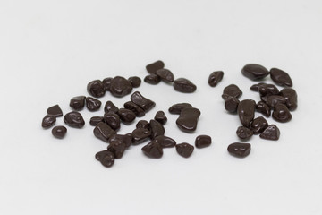 Confectionery dark chocolate in dragee on a white background