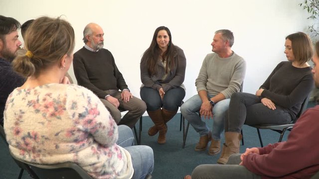 4K: Support group people sat in circle for therapy Counselling session - One woman talks while others listen. Mental Heath, Alcoholic