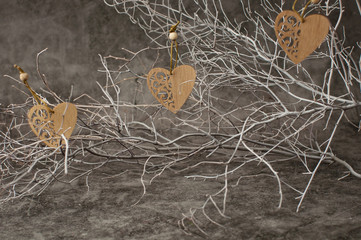 Holiday background for Valentine's Day on a gray cement background with white painted branches and a sheet of paper for text